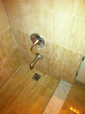 Shower installed and tiled in washroom, faucet, spout and drain plumbing